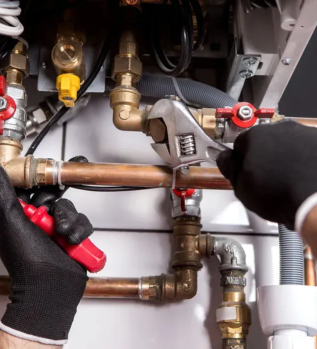 A photograph of two men in tan pants and dark shirts, working together to install a white cabinet in a kitchen